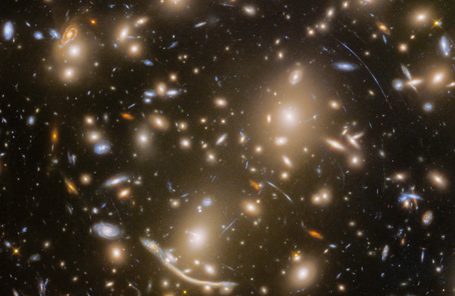 Webb-opname van Abell 370, een cluster van sterrenstelsel op bijna vier miljard lichtjaar van de aarde. Linksonder is de langgerekte ‘Drakenboog’ te zien.  © NASA